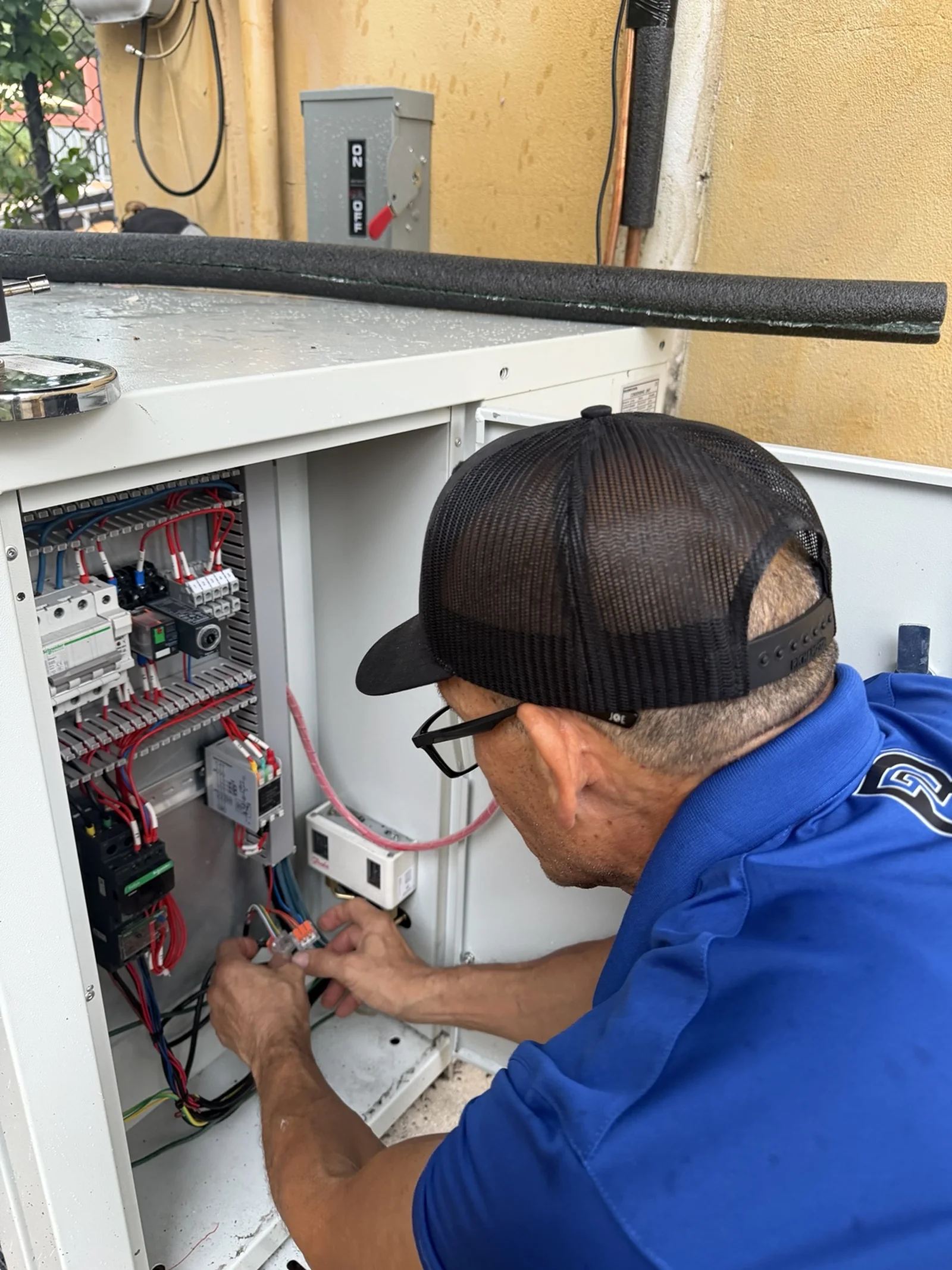 2R Cooling technician working at the condensing-unit control panel