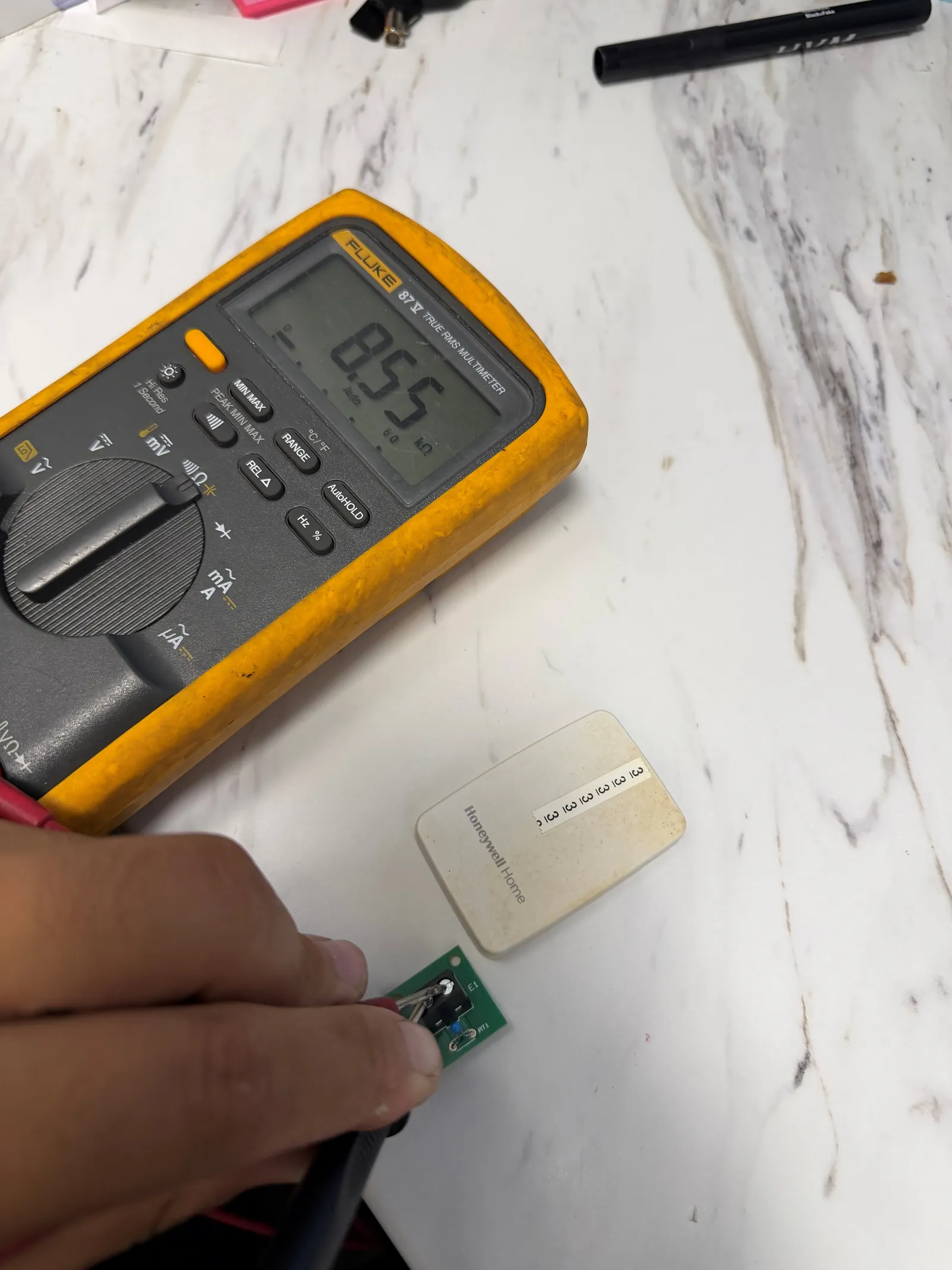 Multimeter reading resistance directly at a 10K NTC remote indoor temperature sensor during commercial HVAC controls diagnosis