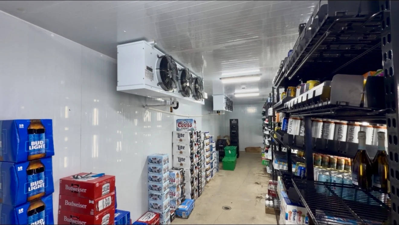 Stocked walk-in cooler interior in Tequesta with two installed evaporators and beverage shelving