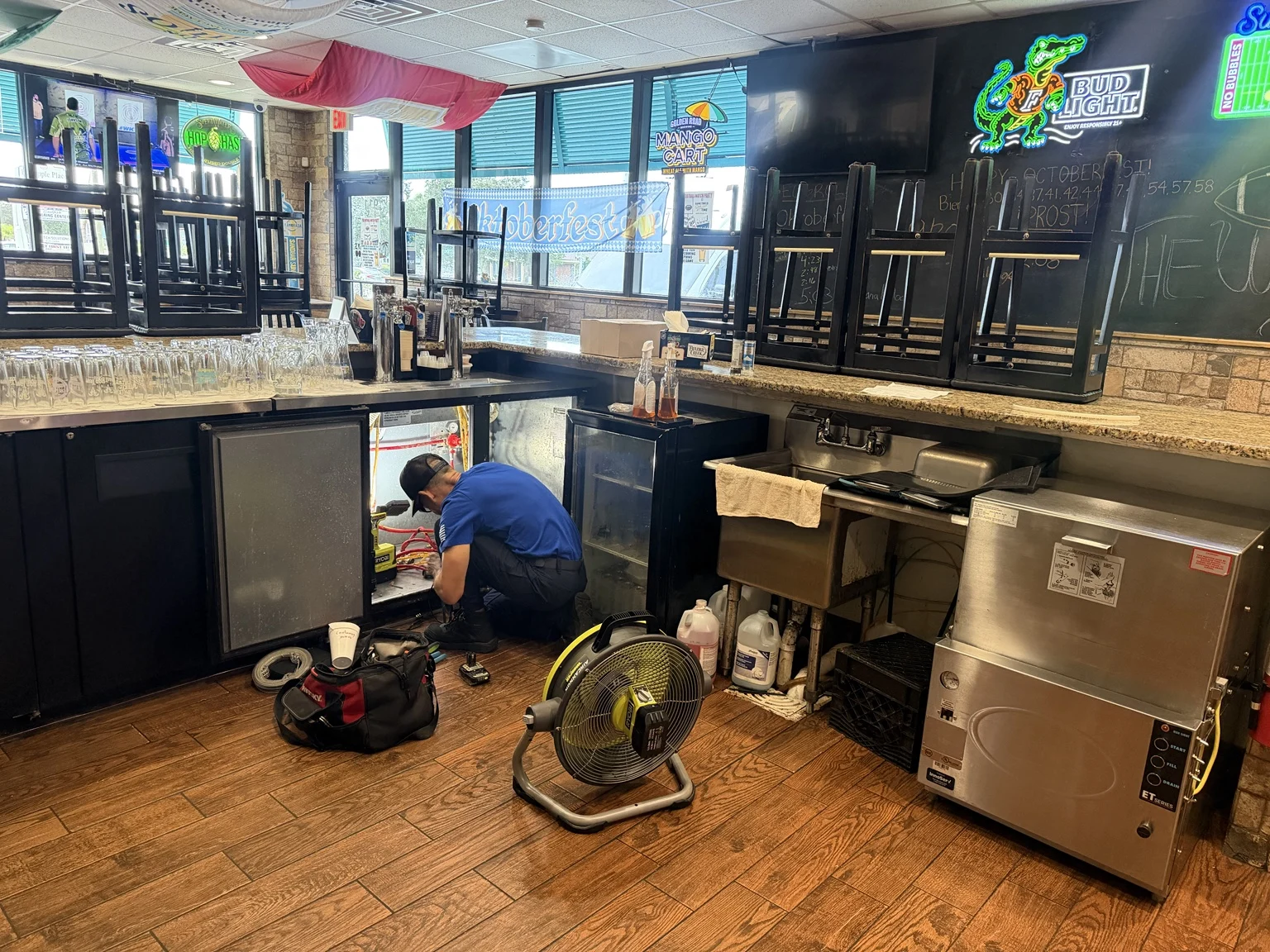 2R Cooling technician servicing a beer-keg cooler behind a Jensen Beach bar
