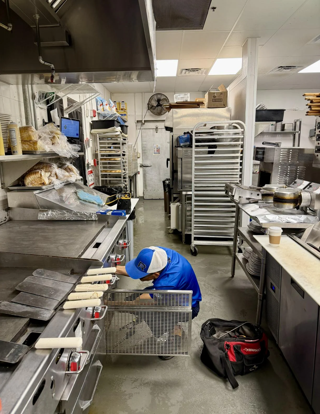 2R Cooling technician servicing an undercounter cooler in a West Palm Beach commercial restaurant kitchen