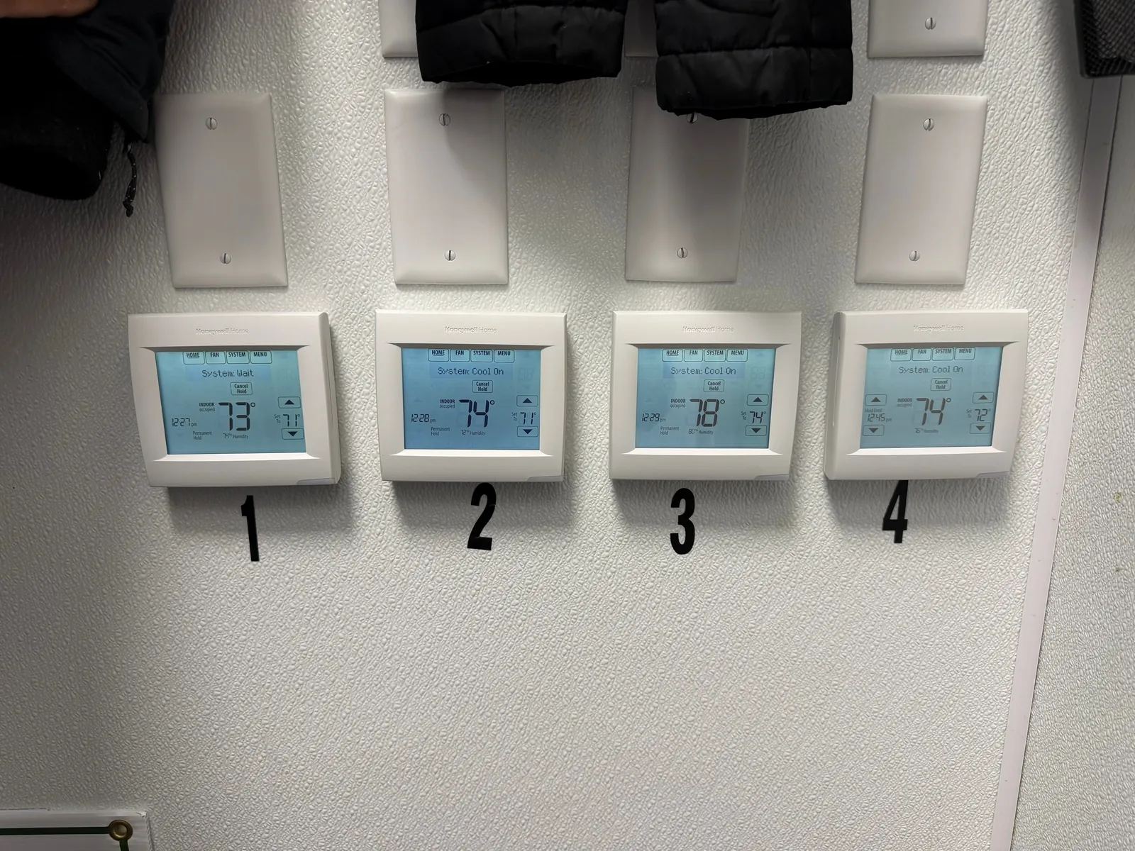 Four Honeywell commercial thermostats numbered 1 through 4 controlling separate rooftop units at Panera Bread in Melbourne, Florida