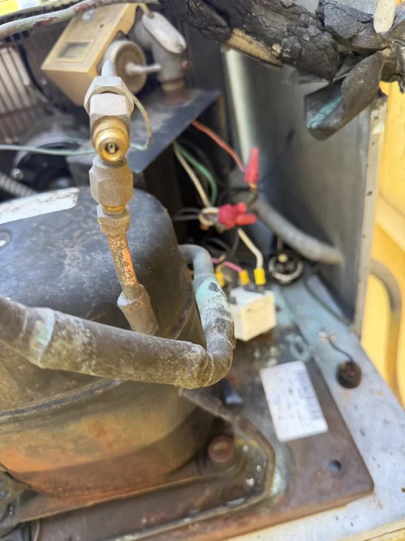 Original compressor piping and electrical connections in the Francesca's Pizza walk-in cooler condensing unit