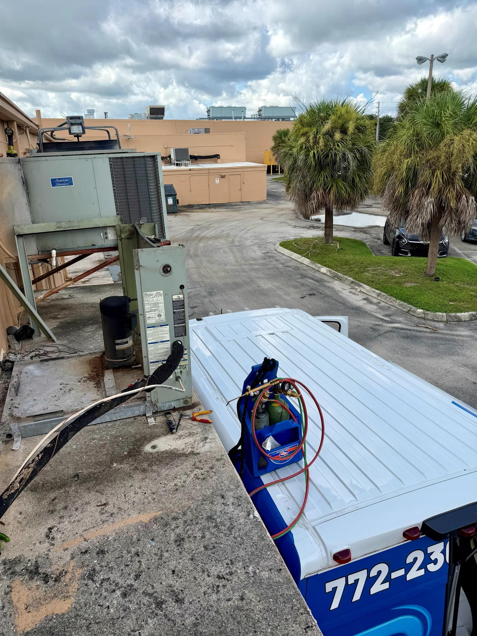 Trane commercial condensing unit at a Fort Pierce commercial facility with 2R Cooling service equipment staged alongside