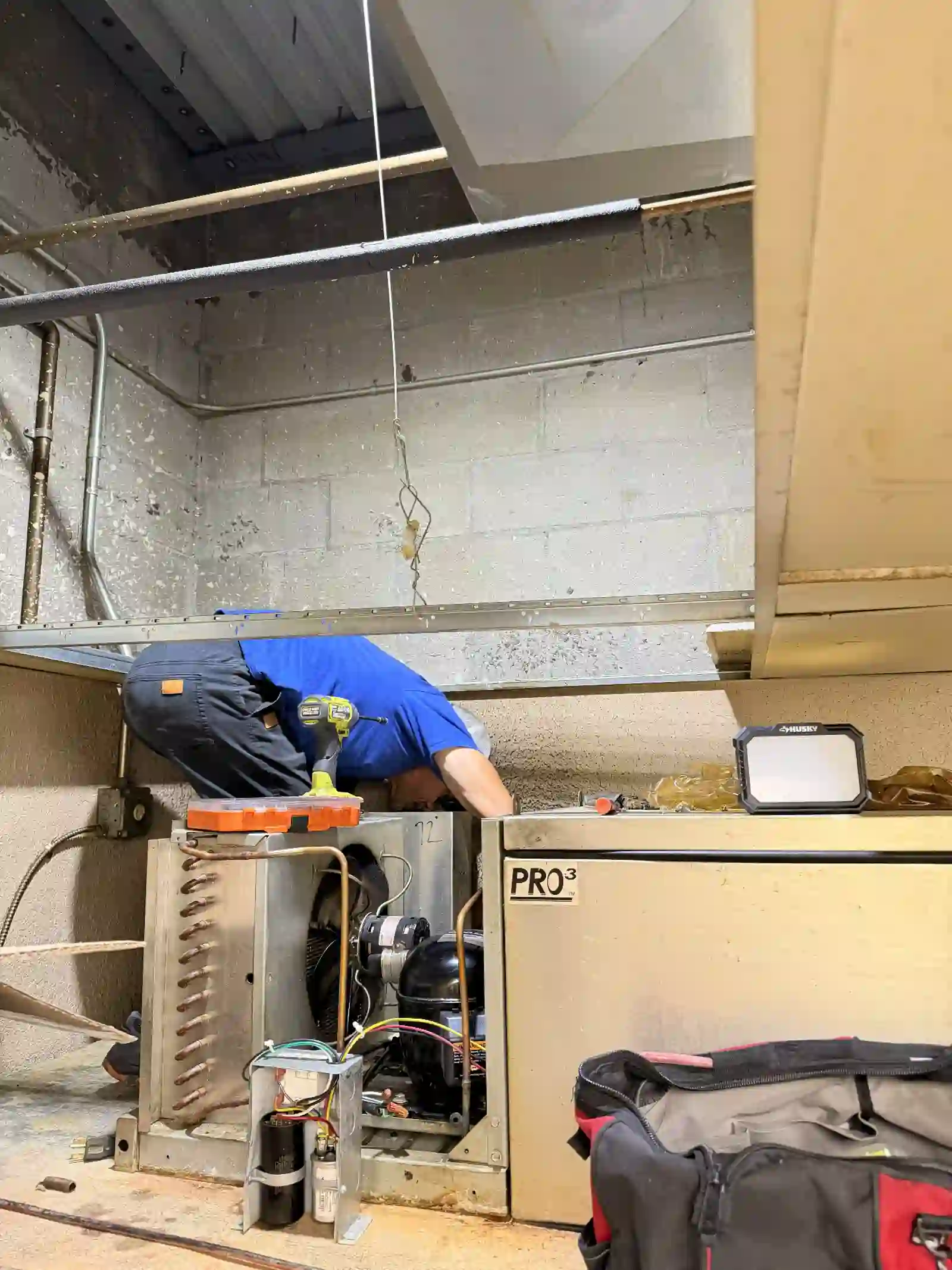2R Cooling technician replacing the condensing unit on the walk-in cooler at Alfonso's Pizza in Port St. Lucie, with the new compressor, copper piping and service tools staged in the back room