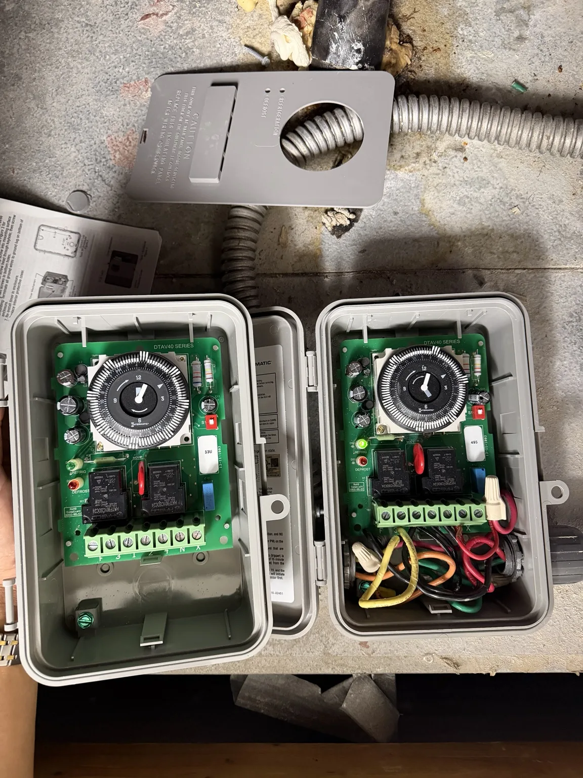 Two Intermatic DTAV40-series defrost timer assemblies side by side during replacement